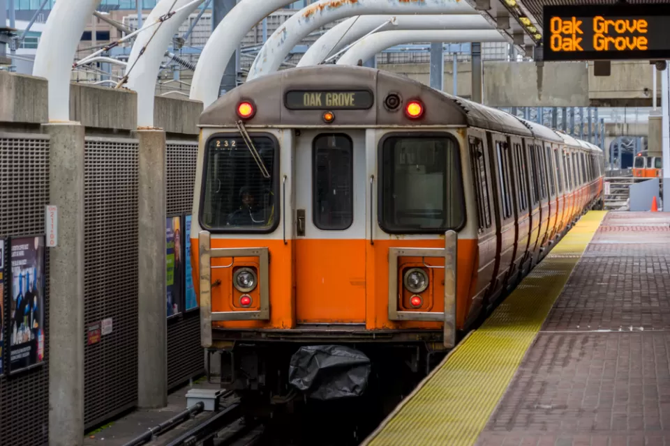 An MBTA Orange Line train bound for Oak Grove waits at a station.